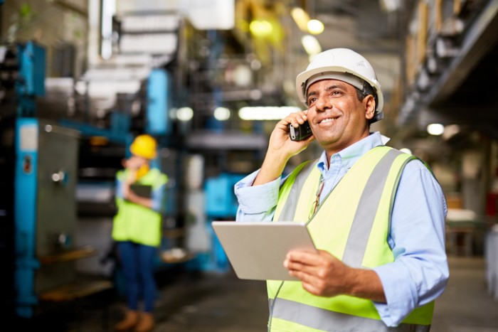 Smiling worker with radio controlling the work process